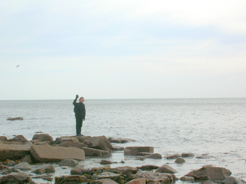 Photograph: Ed stands waving on a rock, quite pleased with himself